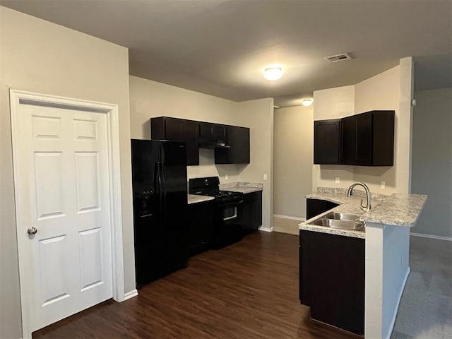 kitchen with black appliances, light stone counters, dark hardwood / wood-style flooring, and sink