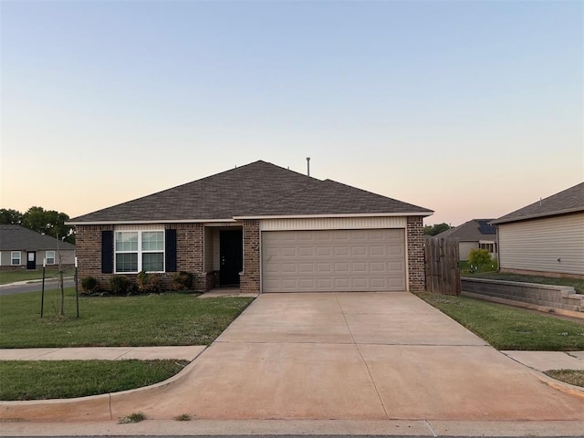 single story home featuring a lawn and a garage