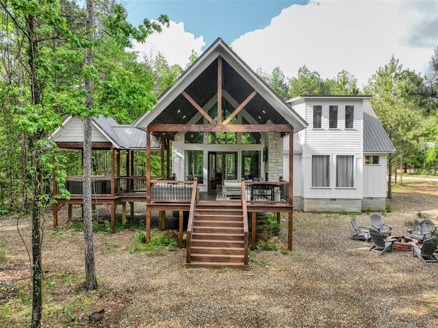 back of house featuring a fire pit and a deck