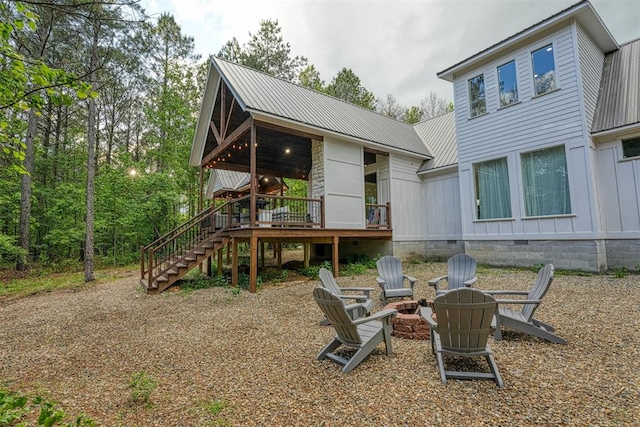 back of house with a deck and an outdoor fire pit