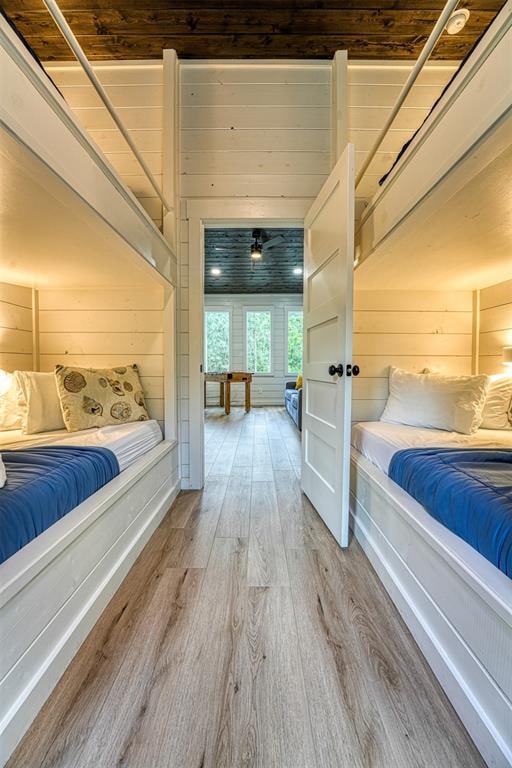 bedroom with wood walls, wood-type flooring, and wooden ceiling