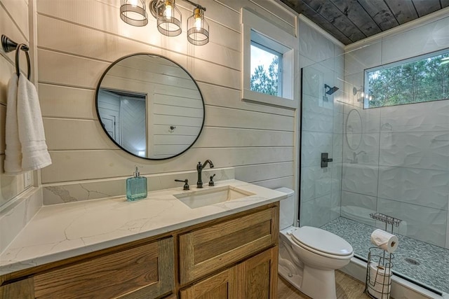 bathroom featuring toilet, wood walls, and a tile shower