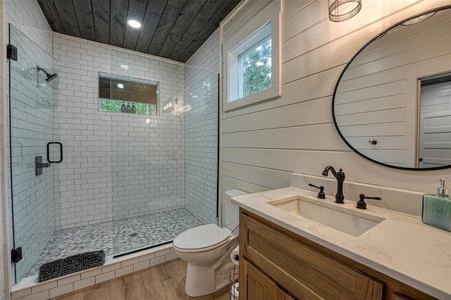 bathroom featuring vanity, toilet, wood-type flooring, and wooden walls