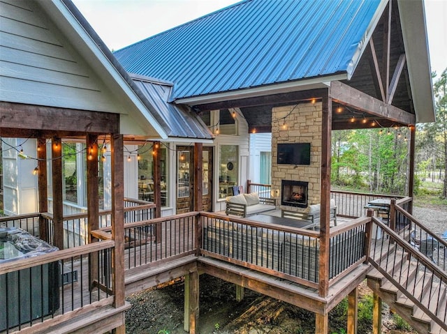 wooden deck featuring an outdoor stone fireplace