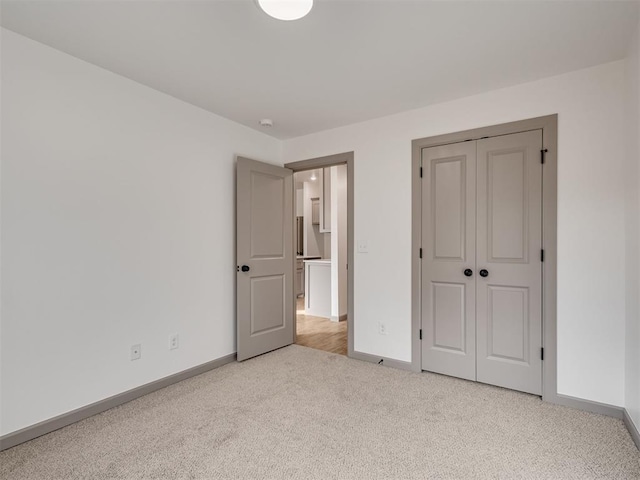 unfurnished bedroom featuring a closet and light carpet