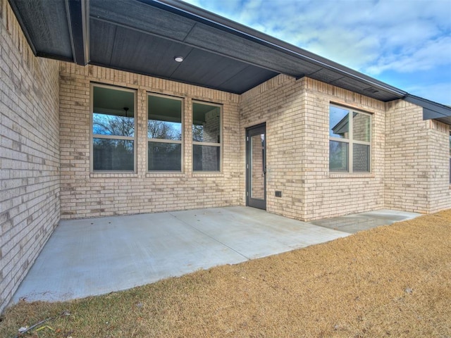 view of exterior entry with a patio