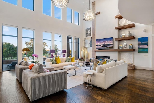 living room featuring a chandelier, a high ceiling, and dark hardwood / wood-style flooring