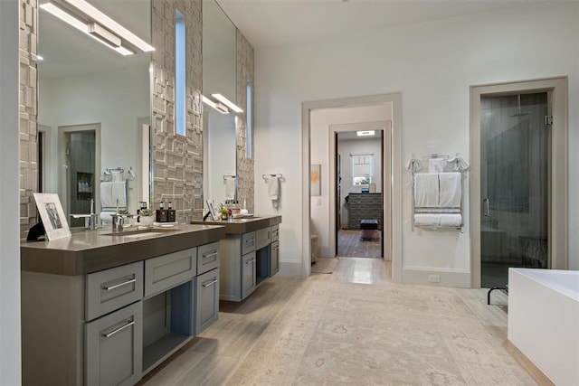 bathroom featuring hardwood / wood-style flooring, vanity, and separate shower and tub