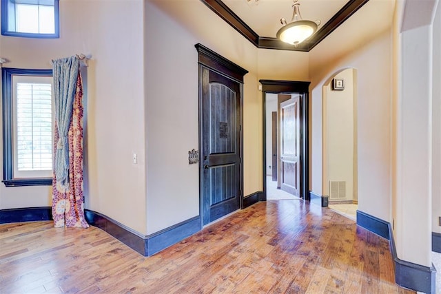 foyer featuring ornamental molding and hardwood / wood-style flooring