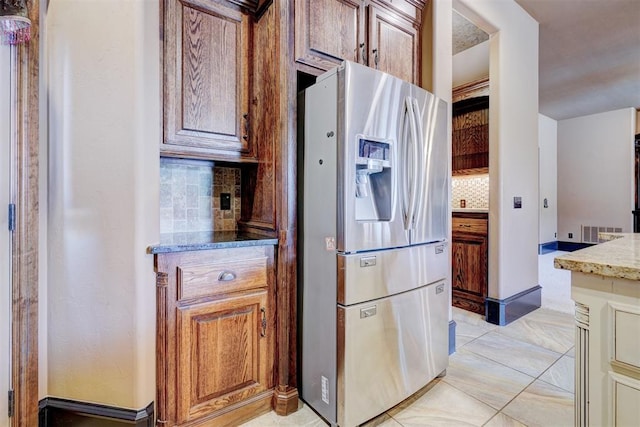 kitchen with decorative backsplash and stainless steel refrigerator with ice dispenser