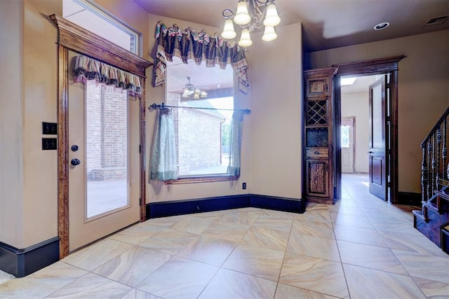 entryway featuring ceiling fan with notable chandelier and a healthy amount of sunlight