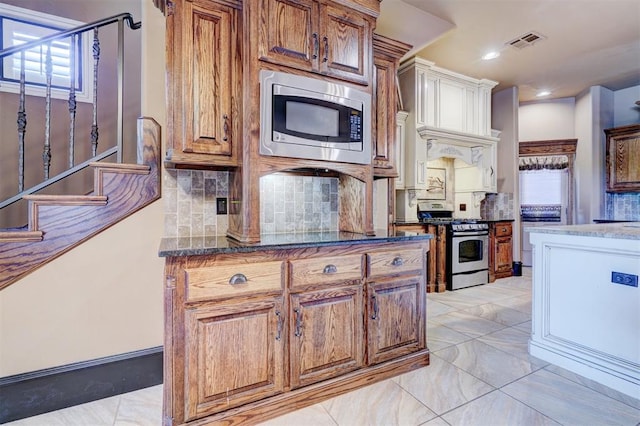 kitchen with tasteful backsplash and appliances with stainless steel finishes