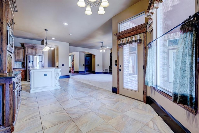 foyer entrance featuring ceiling fan with notable chandelier