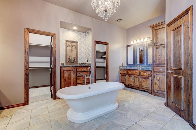 bathroom featuring a tub, vanity, and a chandelier