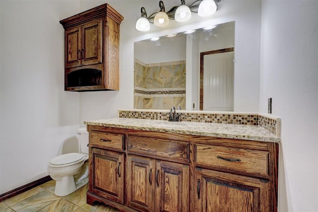 bathroom featuring vanity, toilet, decorative backsplash, and tiled shower