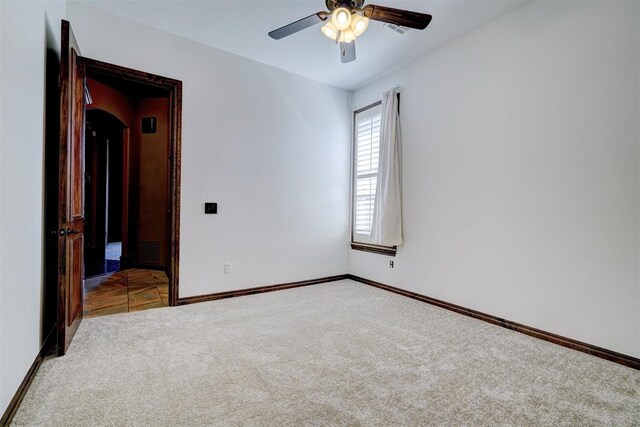 carpeted spare room with ceiling fan