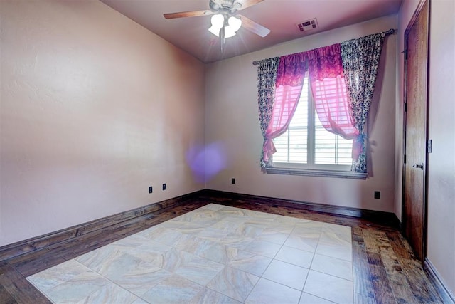 spare room with ceiling fan and light wood-type flooring