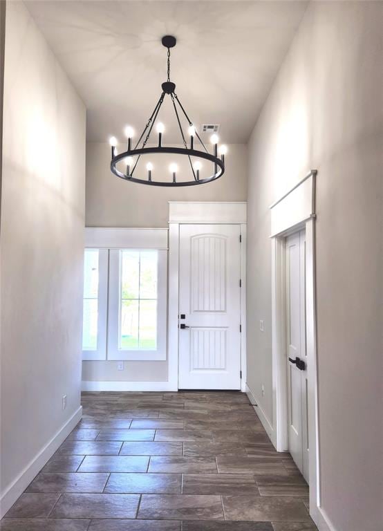 entrance foyer with dark hardwood / wood-style flooring and an inviting chandelier