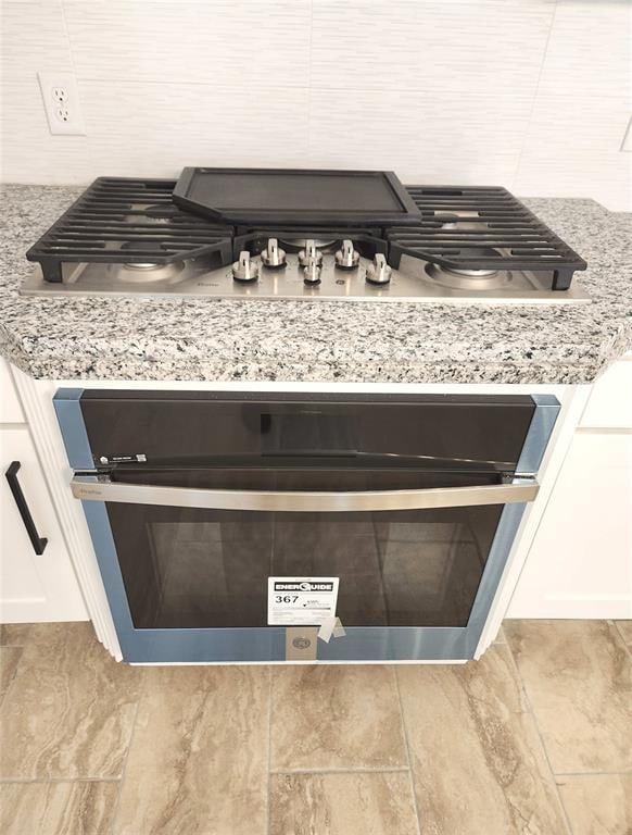 details with light stone countertops and white cabinetry