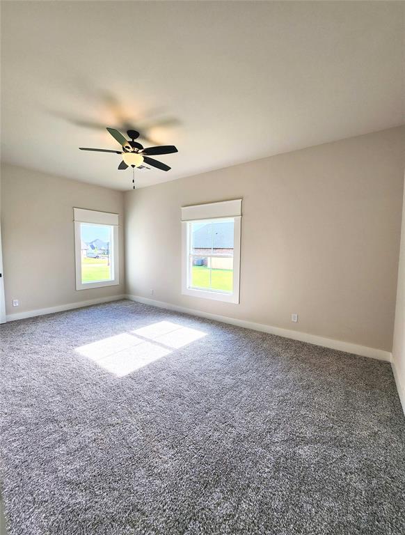 unfurnished room featuring ceiling fan and carpet floors