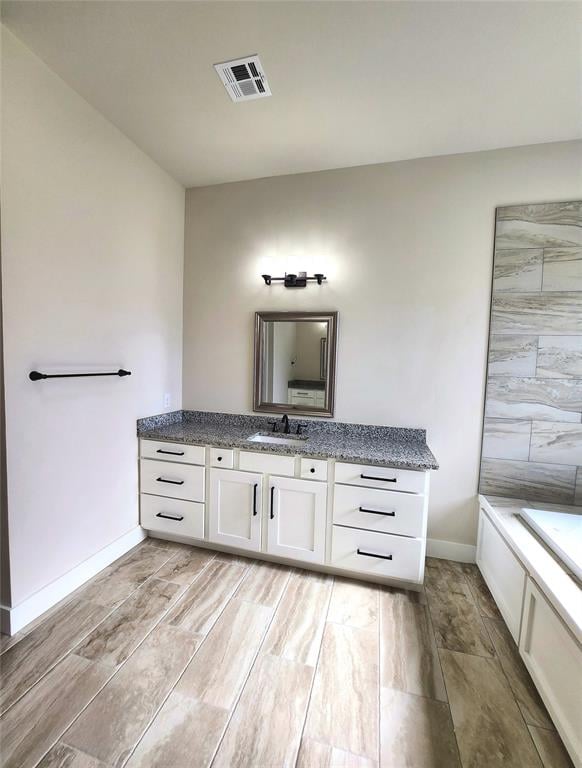 bathroom featuring hardwood / wood-style floors, vanity, and a bathtub