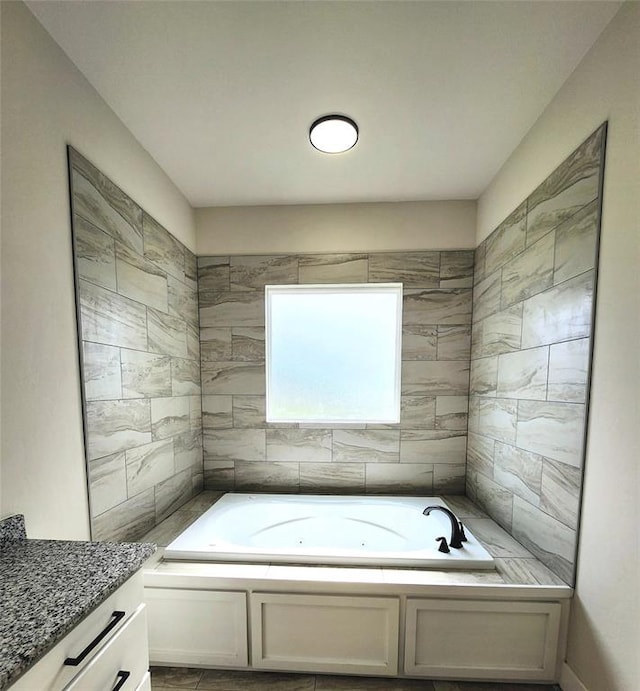 bathroom featuring vanity and a bath