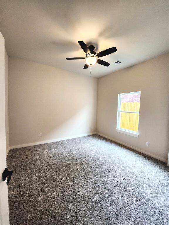 spare room featuring carpet floors and ceiling fan