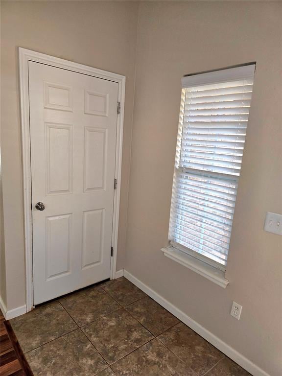 interior space with plenty of natural light and dark tile patterned floors