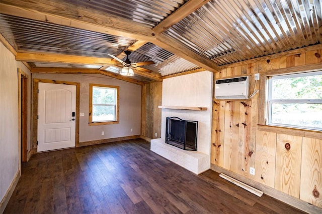 unfurnished living room with a wall mounted air conditioner, dark hardwood / wood-style flooring, wooden walls, lofted ceiling with beams, and a fireplace