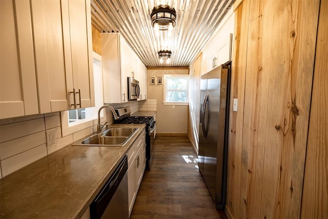 kitchen featuring dark wood-type flooring, white cabinets, sink, decorative backsplash, and appliances with stainless steel finishes