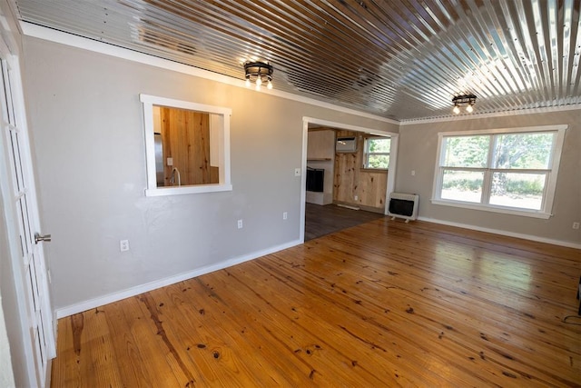 unfurnished living room with hardwood / wood-style floors, a wall unit AC, and heating unit