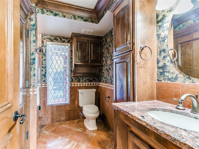 bathroom featuring vanity, ornamental molding, tile walls, and toilet