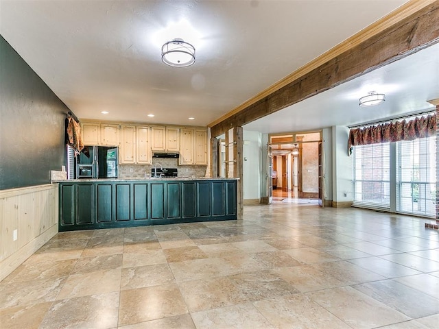 kitchen with backsplash, black appliances, and cream cabinetry