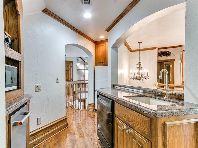 kitchen featuring light wood-type flooring, sink, an inviting chandelier, black dishwasher, and hanging light fixtures