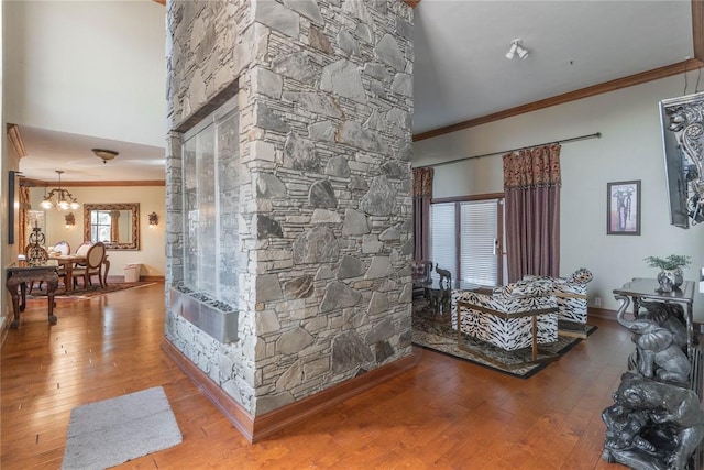 living room with hardwood / wood-style floors, ornamental molding, and an inviting chandelier