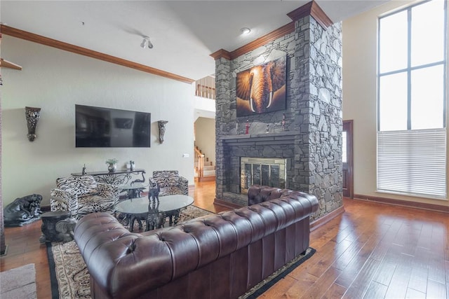 living room featuring a fireplace, wood-type flooring, and ornamental molding