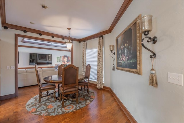 dining area featuring hardwood / wood-style floors and crown molding