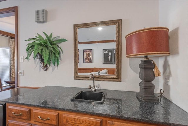 kitchen featuring dark stone countertops and sink