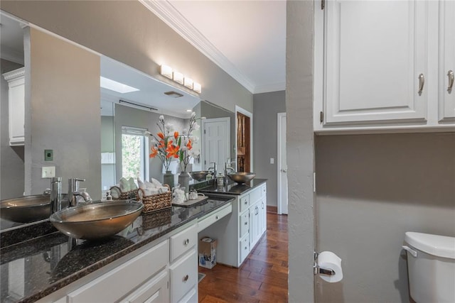 bathroom with vanity, hardwood / wood-style flooring, toilet, and ornamental molding