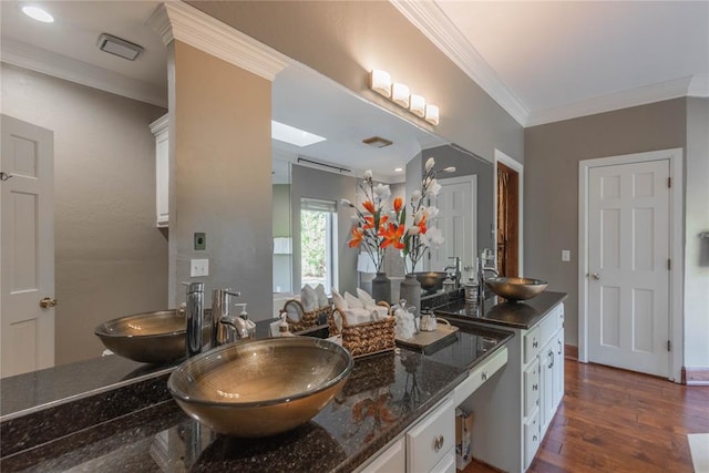 bathroom with hardwood / wood-style flooring, vanity, and ornamental molding