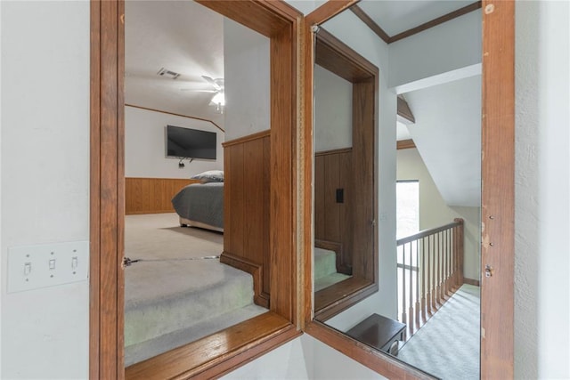 hall featuring wood walls and vaulted ceiling