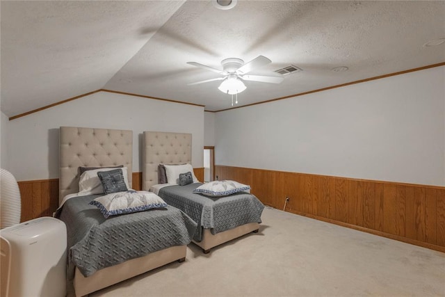 carpeted bedroom with ceiling fan, wood walls, lofted ceiling, and a textured ceiling