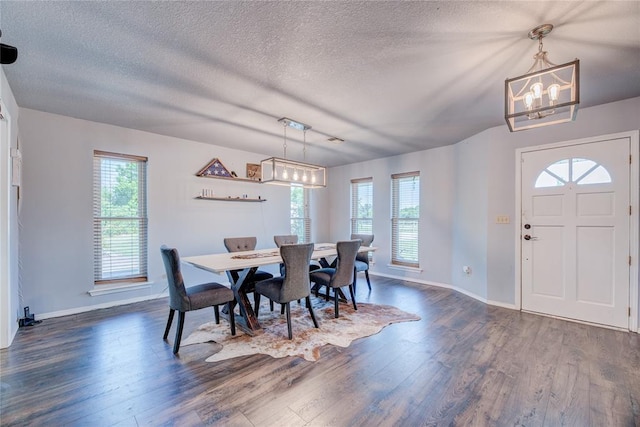 dining room featuring a notable chandelier, dark hardwood / wood-style floors, and a textured ceiling