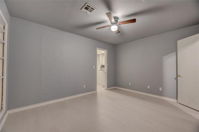 empty room with a textured ceiling and ceiling fan