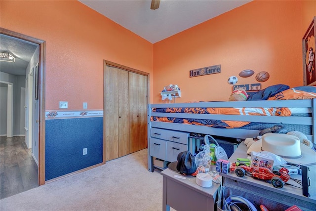 bedroom with light carpet, ceiling fan, and a closet