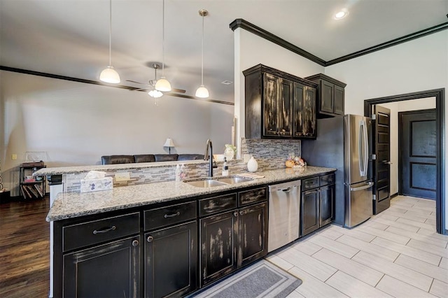 kitchen featuring pendant lighting, light stone counters, sink, and stainless steel appliances