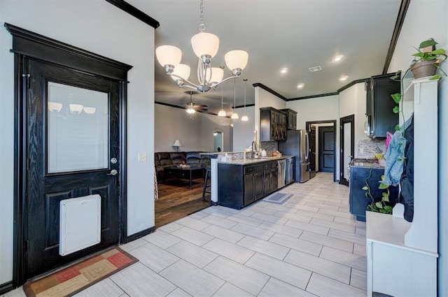 kitchen with dark brown cabinetry, tasteful backsplash, light stone counters, light hardwood / wood-style flooring, and decorative light fixtures