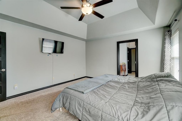 bedroom featuring light colored carpet, ceiling fan, and a tray ceiling