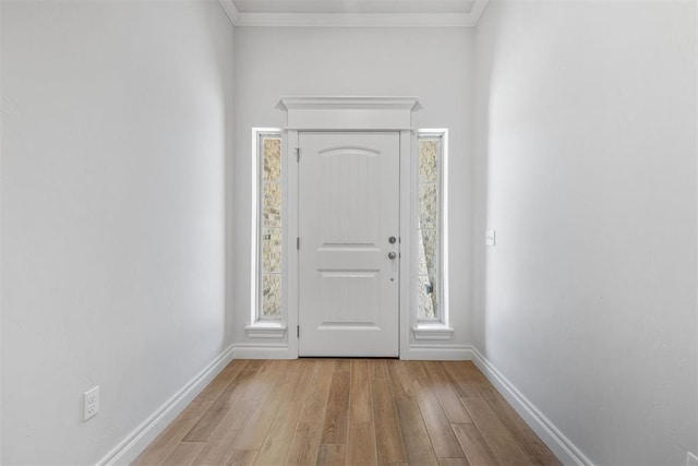 entryway with light wood-type flooring and crown molding