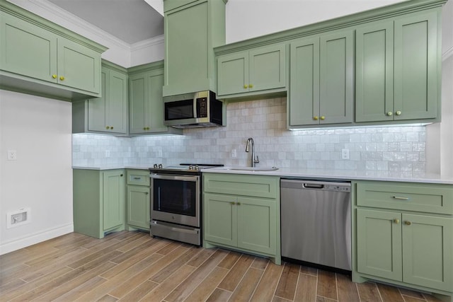 kitchen featuring sink, stainless steel appliances, light wood-type flooring, and green cabinetry